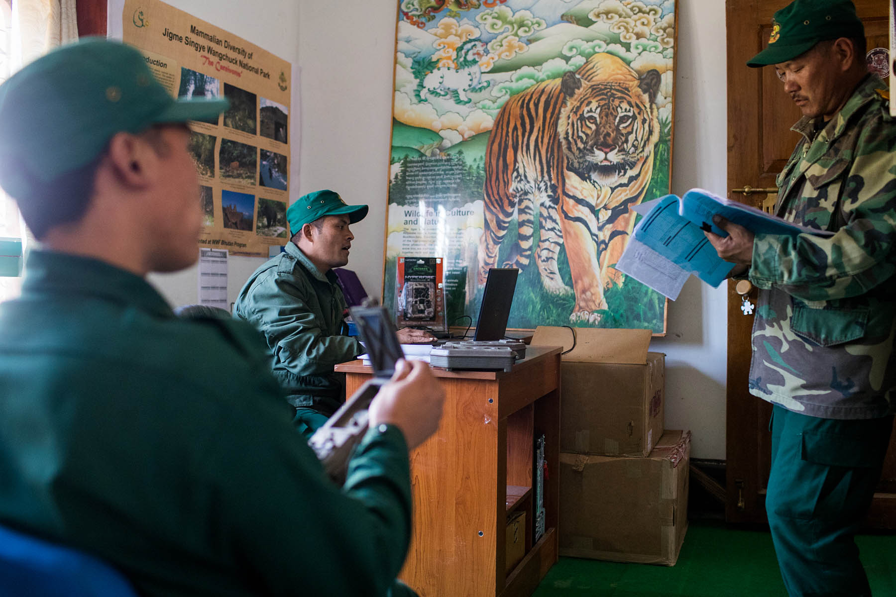 Rangers in the Jime Singye National Park office are studying camera trap data.